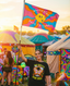 A smiling person holds the Wandering Back to Camp Festie Flag Doublesided at a vibrant outdoor festival, surrounded by decorated tents, twinkling lights, and fellow attendees. This bold and colorful flag stands out as both a joyful statement piece and an inviting decoration for any campsite in the lively festival atmosphere.