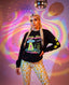 A woman wearing a black sweatshirt with a colorful graphic and yellow stars poses in front of a disco ball and a colorful, swirling background.